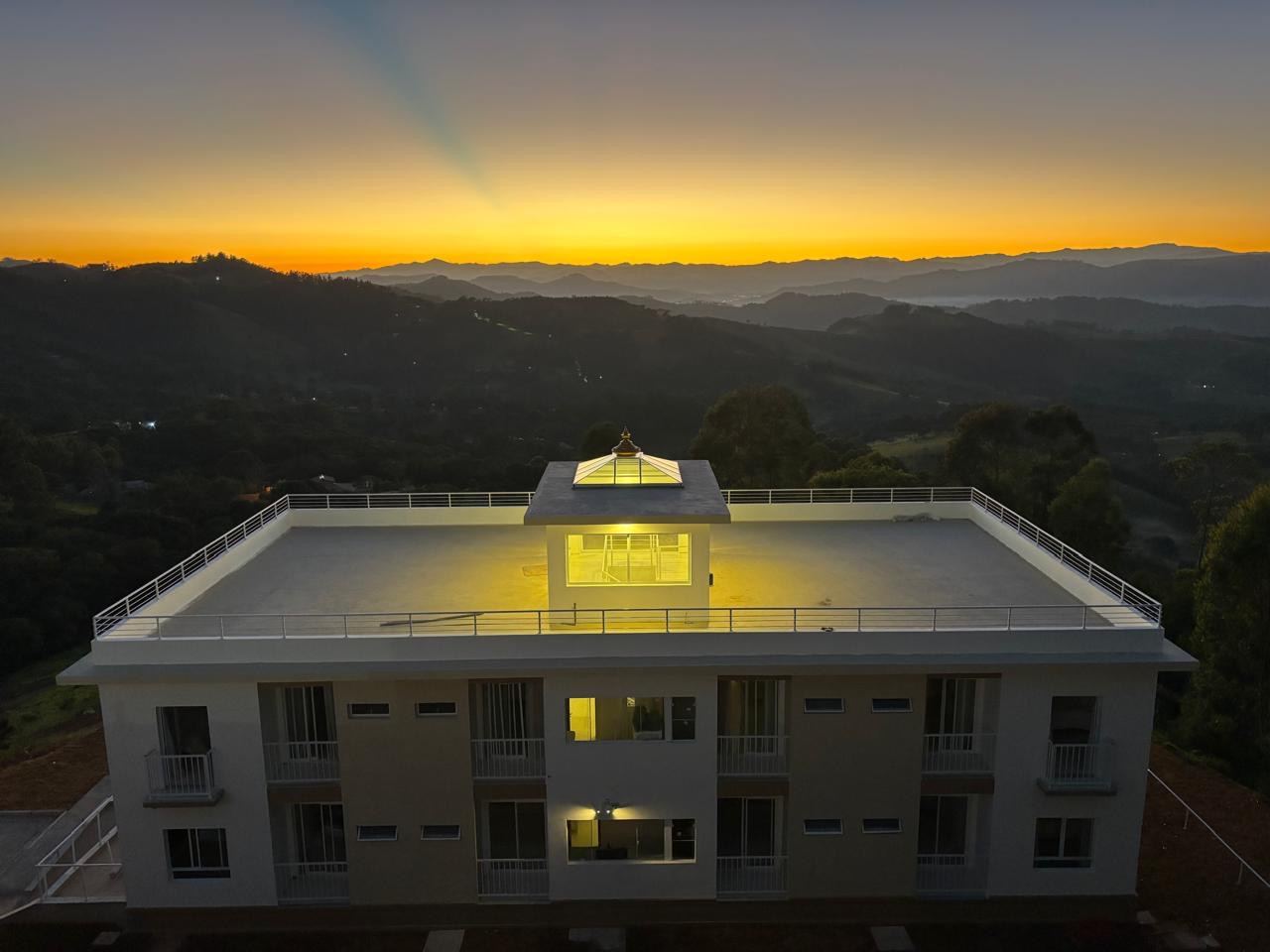 Edifício ao entardecer, com a torre iluminada